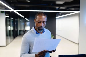 Black man reading papers in office