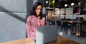 Woman at laptop in red and white blouse