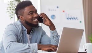 african-worker-talking-on-cellphone-and-using-laptop