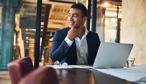 cheerful-office-employee-sitting-at-his-laptop