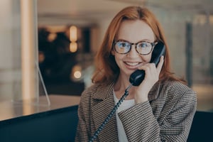 Female office worker with glasses on phone