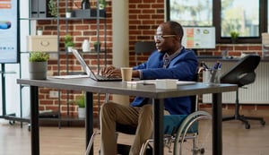 paralyzed-employee-in-wheelchair-using-laptop-to